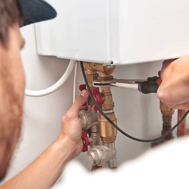 A maintenance worker repairing a boiler